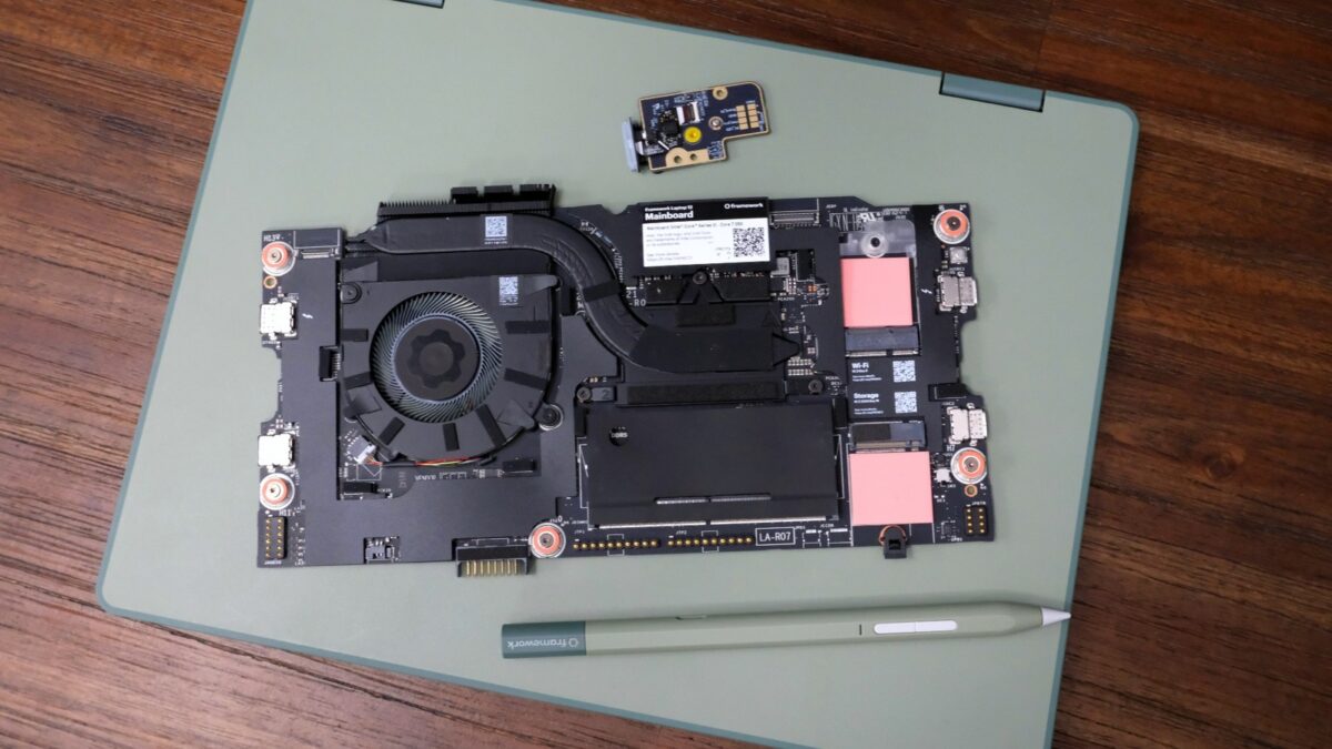 Framework Laptop 12 on a table, on top of which is the new mainboard, fingerprint reader and stylus.
